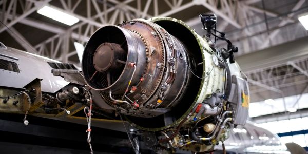 Close-up of a jet engine on an aircraft in a hangar.