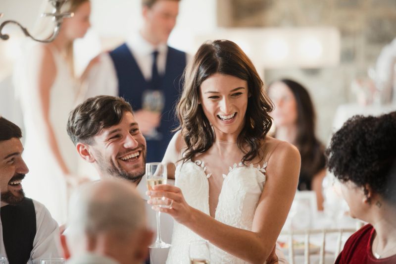 Happy bride and groom are socialising with the guests at their wedding reception.