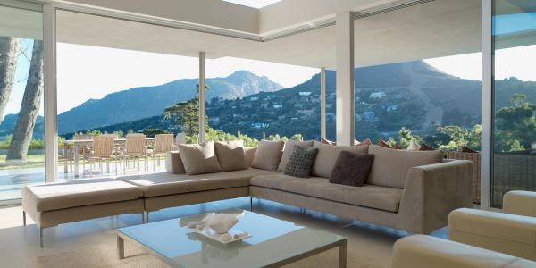 Modern living room with mountain view and large sectional sofa.