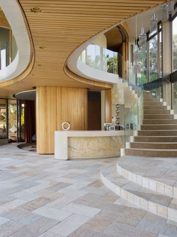 Modern interior with curved staircase and wooden ceiling accents.