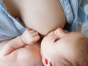 A newborn breastfeeding calmly from mother.