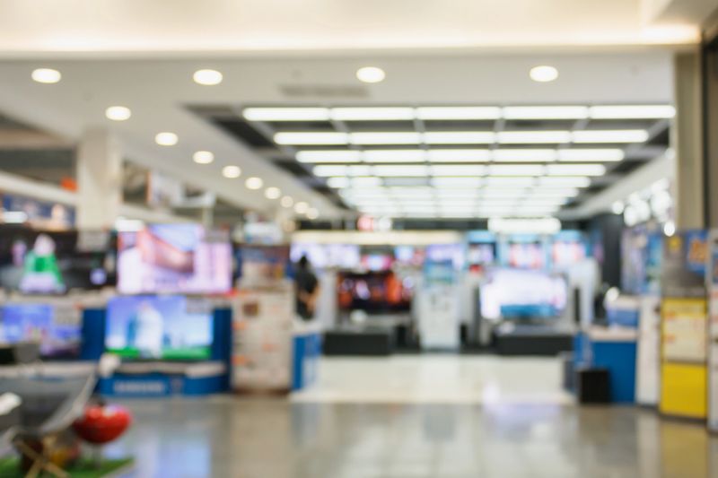 Television Smart TVs 4K Ultra HD home entertainment display on shelves in eletronic department retail store abstract blur defocused background