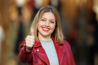 Smiling woman giving thumbs up.