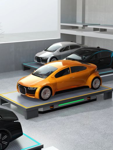 Orange car parked on an automated lift platform inside a modern parking facility