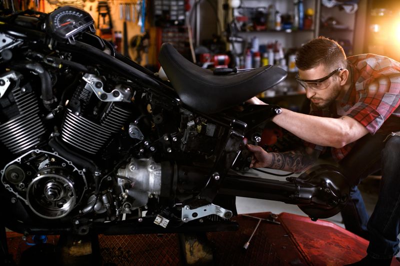 Mechanic in auto repair shop is customizing motorcycle engine.