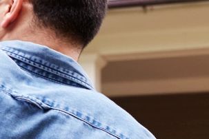 Back view of a person wearing a denim jacket.