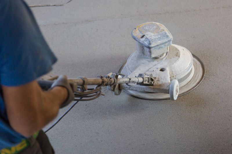 Laborer performing and polishing sand and cement screed floor. Sand and cement floor screed.