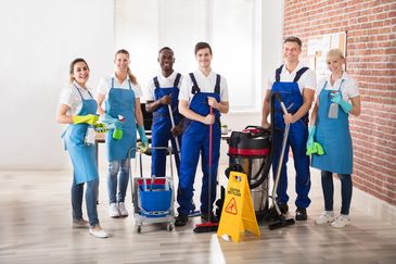 A group of professional cleaners with cleaning tools posing.
