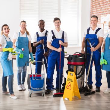 Group of cleaning staff posing with cleaning equipment.