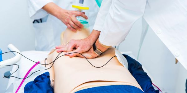 Medical training on CPR using a mannequin and defibrillator.