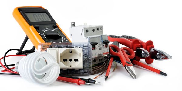 Variety of electrical tools and components arranged on a white surface.