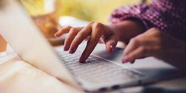 A person using a laptop on top of a table.