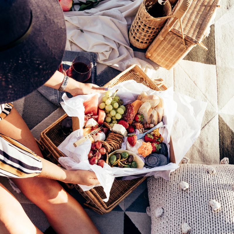 Romantic picnic set up with mixed food platter and wine at sunset