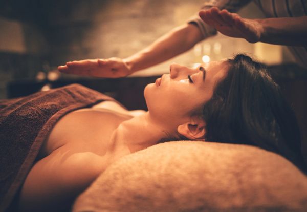 A woman receiving a relaxing spa treatment with warm lighting.