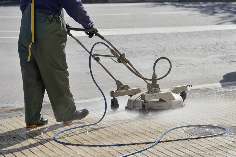 image of worker washes the pavement