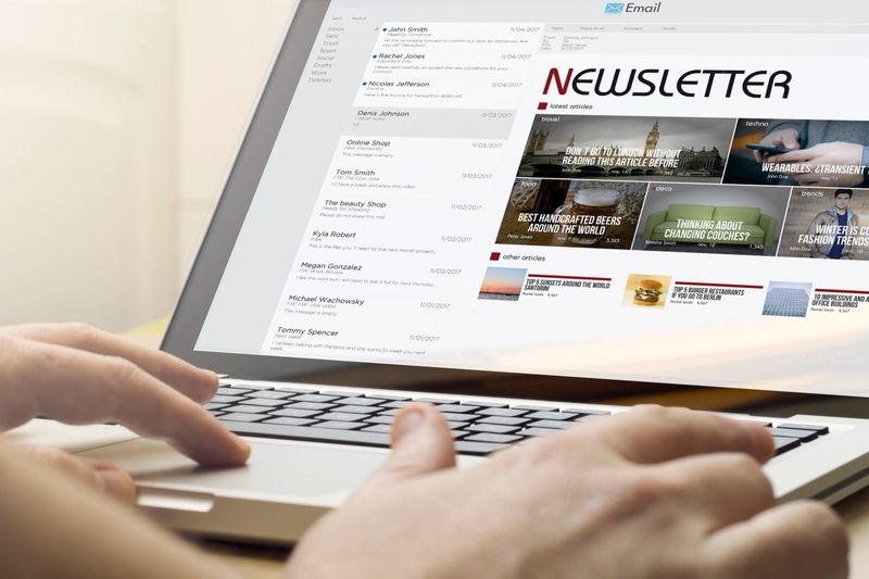 online business concept: man using a laptop with mail client newsletter on the screen. Screen graphics are made up.