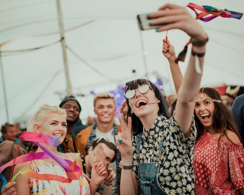 Group of friends taking a selfie at a music festival.
