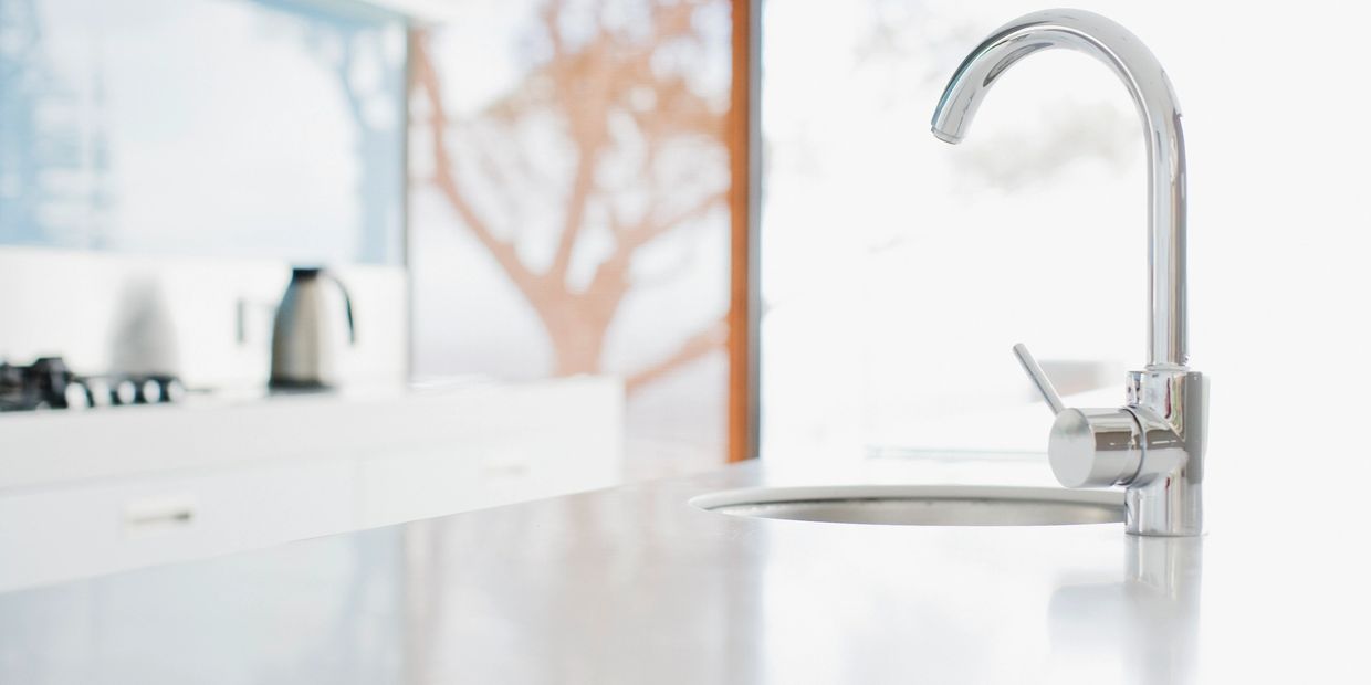 White kitchen countertop with silver sink.