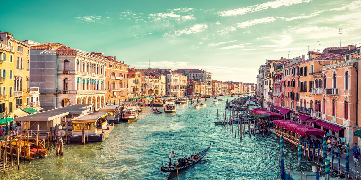 Vibrant Venice canal with gondolas and historic buildings.