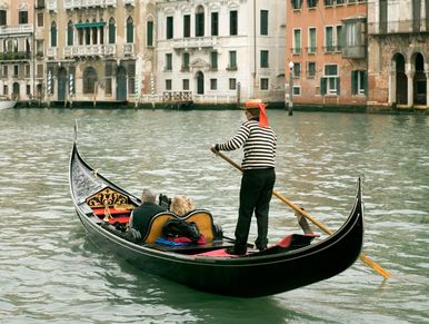 Gondola ride in Venice with tourists and gondolier.