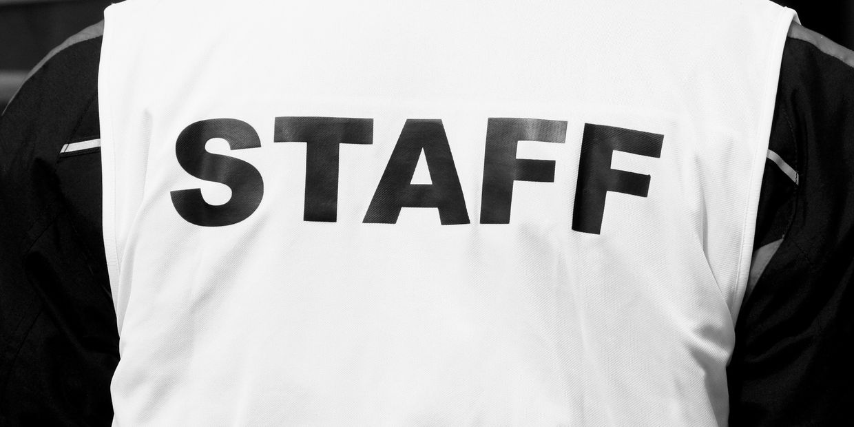 High-visibility vest with STAFF printed on the back.