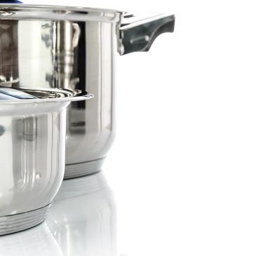 Two stainless steel pots with lids on a reflective surface.