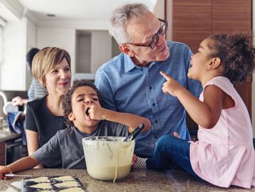 Grandfather enjoys moments with grandchildren in the kitchen.
