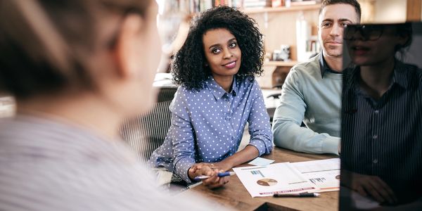 Young professionals discussing data charts in a modern office meeting.