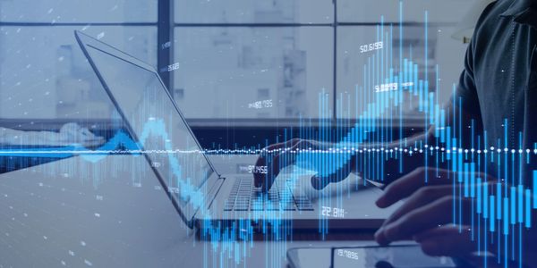 Imagen de un ejecutivo trabajando en su computador mientras se conecta a música y entretenimiento.