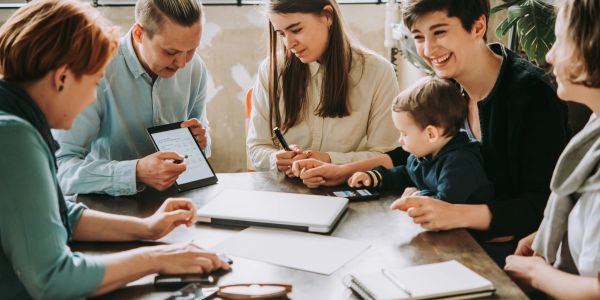 Group discussing work around a table with a child.
