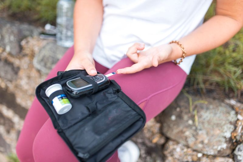 Woman with diabetes measuring blood glucose after workout