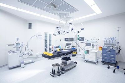 A modern, sterile operating room with advanced medical equipment and bright lighting.