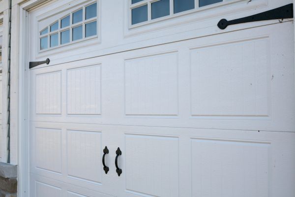 White garage door with decorative handles and windows.