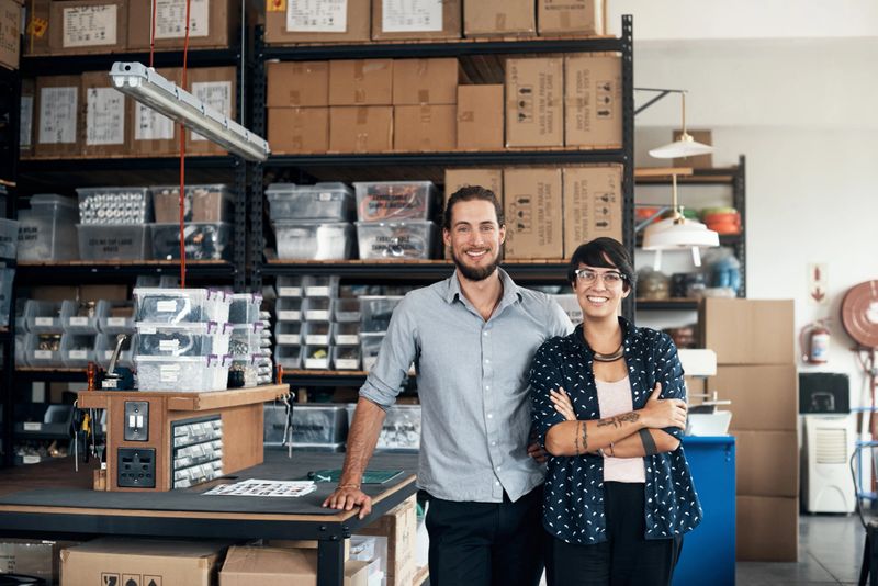Portrait of two colleagues standing in a workshop