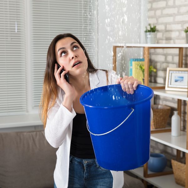 Picture of someone catching water from ceiling into bucket in vacation home in Bradenton Florida