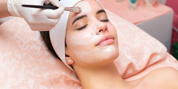 Woman receiving a facial mask treatment at a spa.