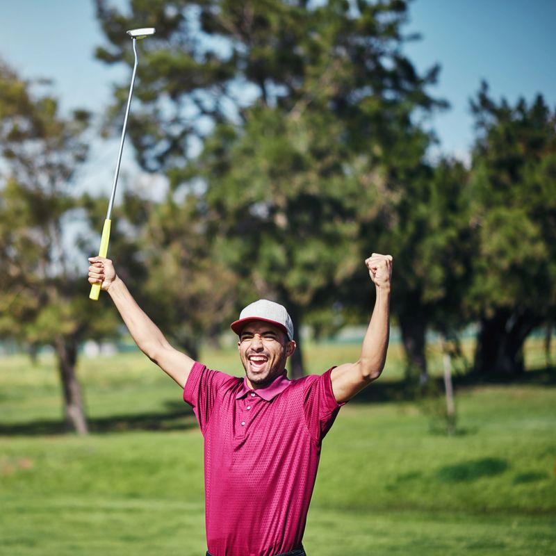 Shot of a cheerful young male golfer lifting up his hands in success of playing a good shot outside during the day