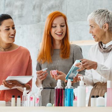 Three women discussing skincare products.