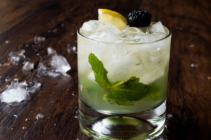 Whiskey Smash Cocktail with Mint Leaves, Lemon, Olive and Crushed Ice. Beverage Concept.