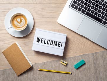 Poste de travail avec pancarte “WELCOME” pour illustrer l’accueil d’un nouveau salarié.