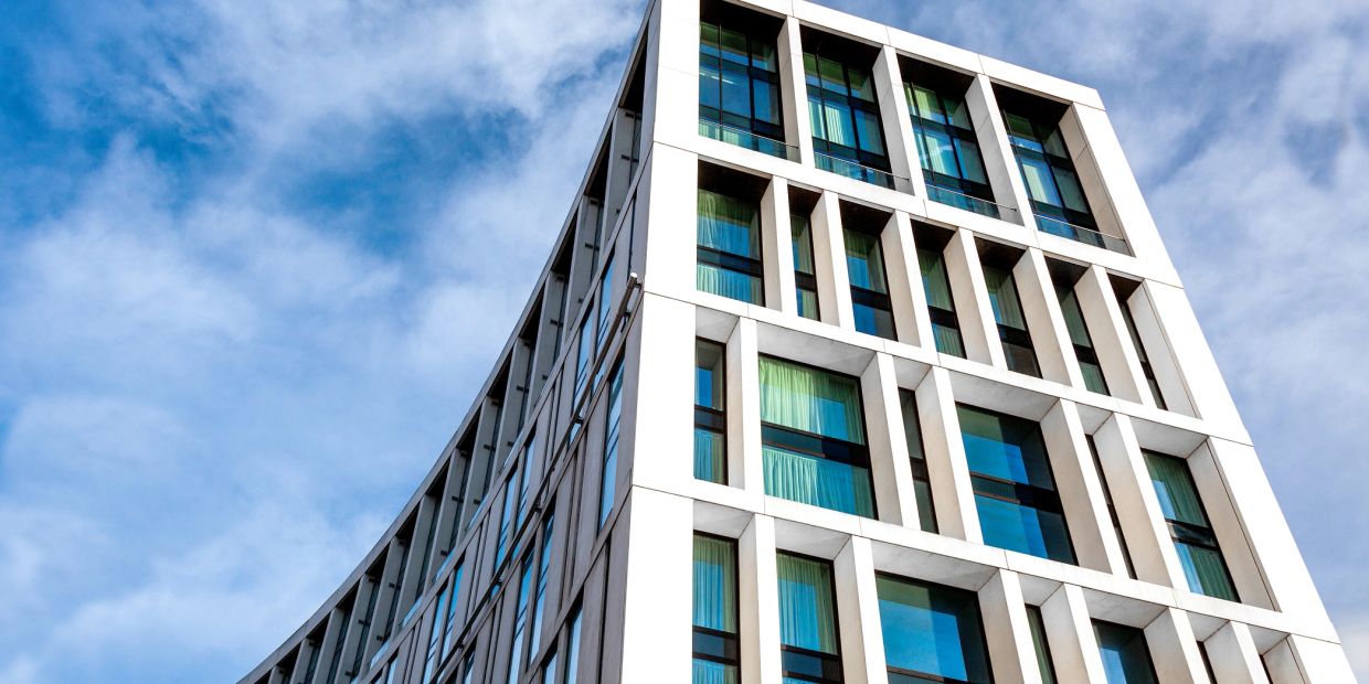 Modern building with large windows against a blue sky.