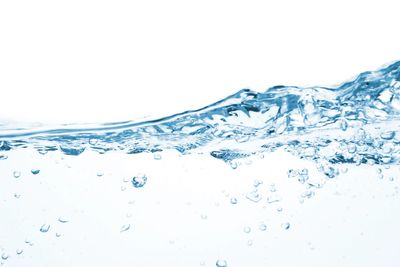 Clear blue water with bubbles and waves on a white background.