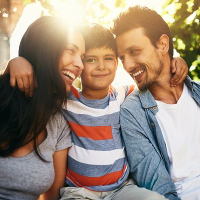 A joyful family with a young boy enjoying a sunny moment together.
