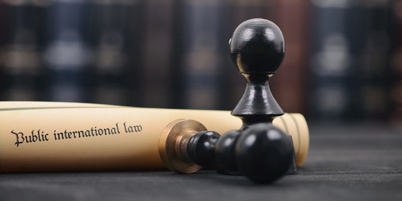 Chess pieces beside an international law scroll, representing document authentication