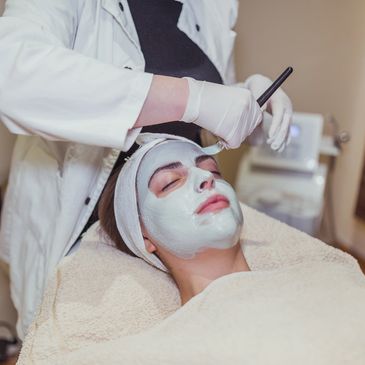 Woman receiving a facial treatment at a spa.