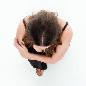 Top-down view of a woman with crossed arms and long hair.