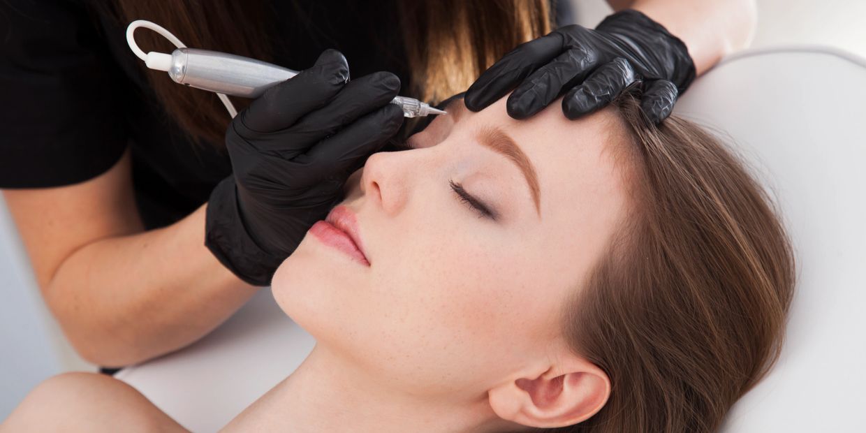 Close-up of microblading eyebrow procedure on a woman.