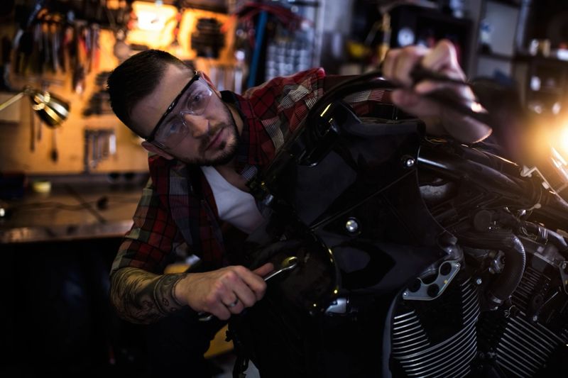 Mechanic in auto repair shop is customizing motorcycle engine.