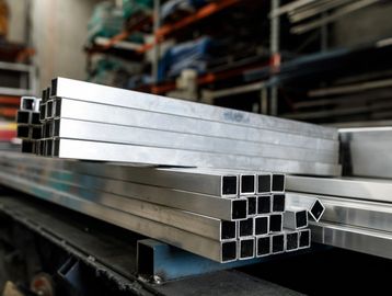 Stack of rectangular metal tubes in a workshop.