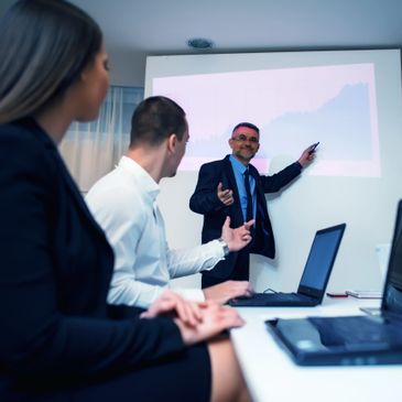 Businessman presenting financial growth chart to colleagues in a meeting.